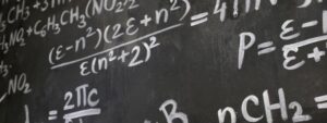 Fórmulas matemáticas y químicas escritas con tiza en una pizarra negra.